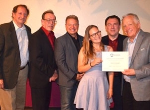 Krista Coppedge graduating from the Renner Academy being presented her certificate by all four instructors and the owner of Renner. 